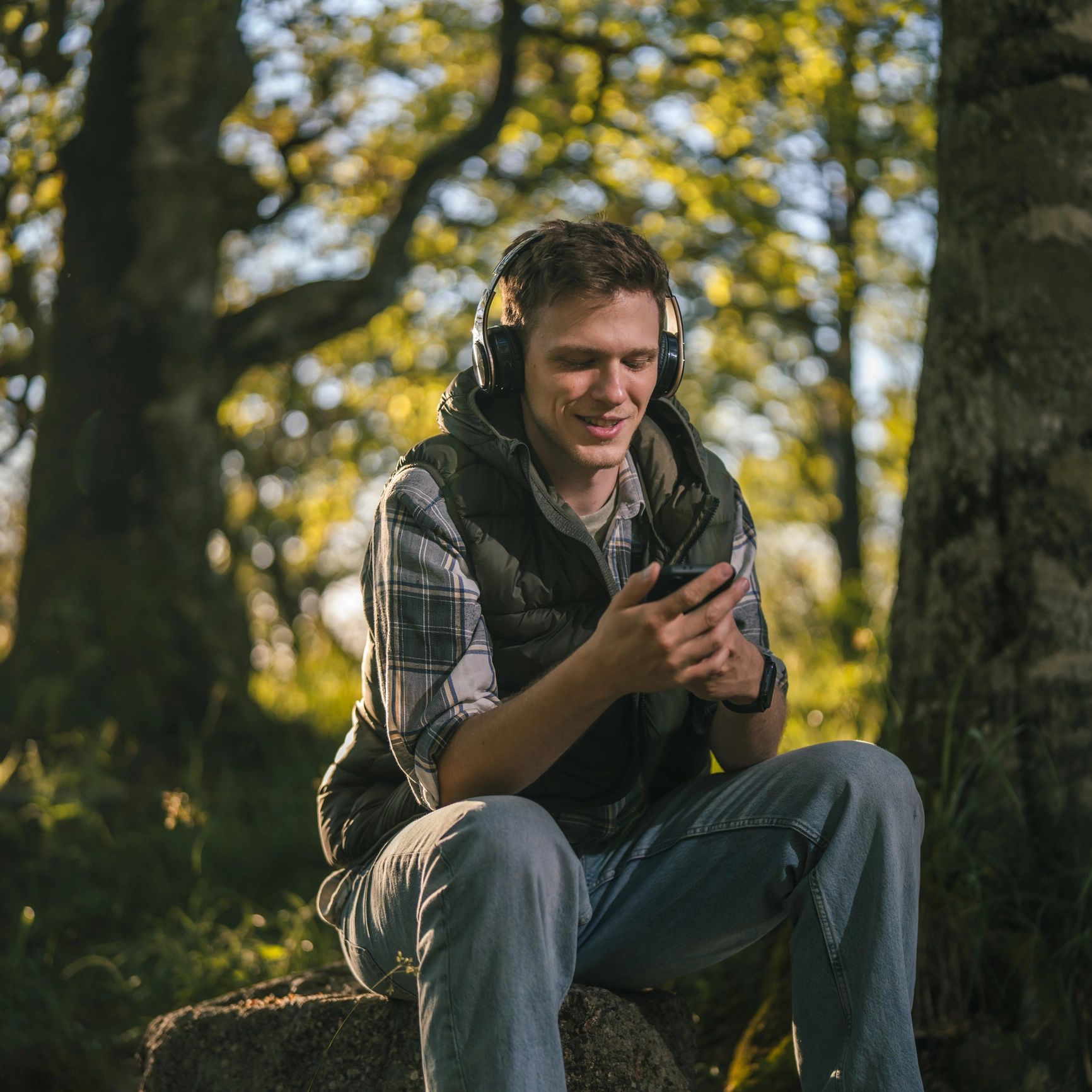 Young man enjoying music on headphones outdoors